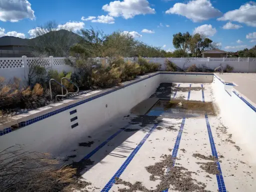 Piscina vuota e sporca, con detriti sul fondo. Immagina come svuotare la piscina con la pompa a sabbia per riportarla al suo antico splendore.