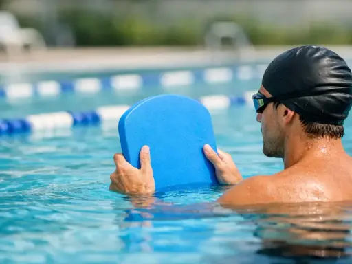 Uomo in piscina con tavoletta blu, pronto per il nuoto con tavoletta per dimagrire.