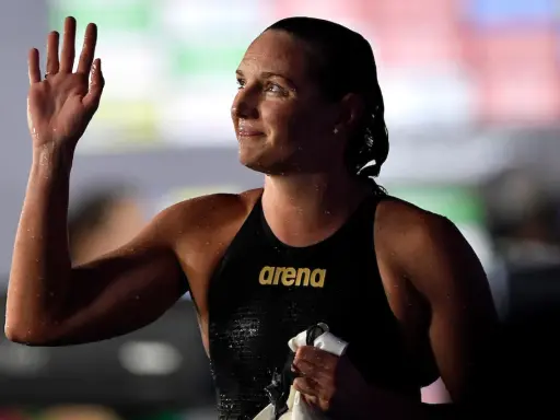 Katinka Hosszu, bagnata e sorridente, saluta con la mano dopo una gara.