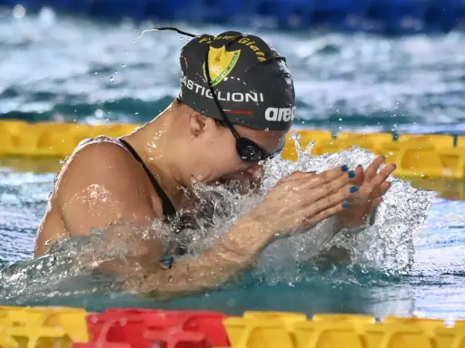 Arianna Castiglioni in azione, con schizzi d'acqua che la circondano durante una gara di nuoto.