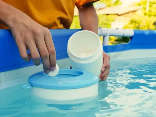 Mano inserisce una pastiglia nel galleggiante per la piscina. Un modo semplice per capire come pulire il filtro della piscina.