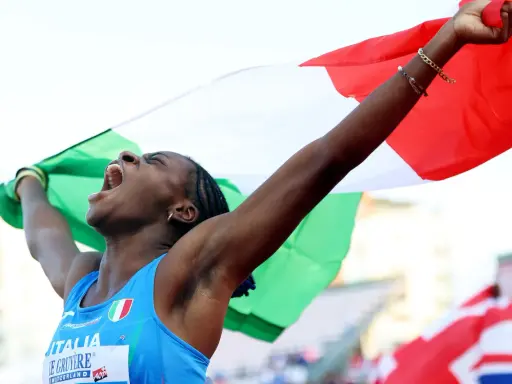 Atleta italiana esulta con la bandiera, un urlo di gioia per il record italiano 100 metri femminile.