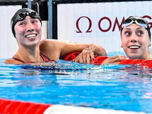 Due nuotatrici sorridono nell'acqua, una con il cappellino "Torri Huske".