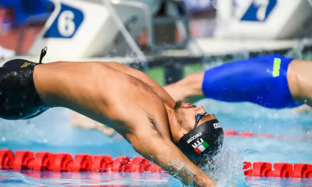 Nuotatore italiano in azione, immersione perfetta in gara. Settecolli nuoto, un tuffo che promette velocità.