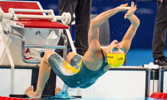 Kaylee McKeown si tuffa in piscina, con le braccia tese e il corpo inarcato, pronta a iniziare la sua gara.