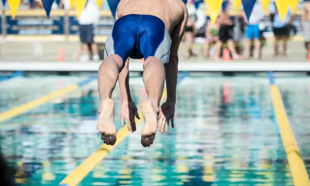 Nuotatore in partenza, dimostrazione dei benefici del nuoto a 50 anni.