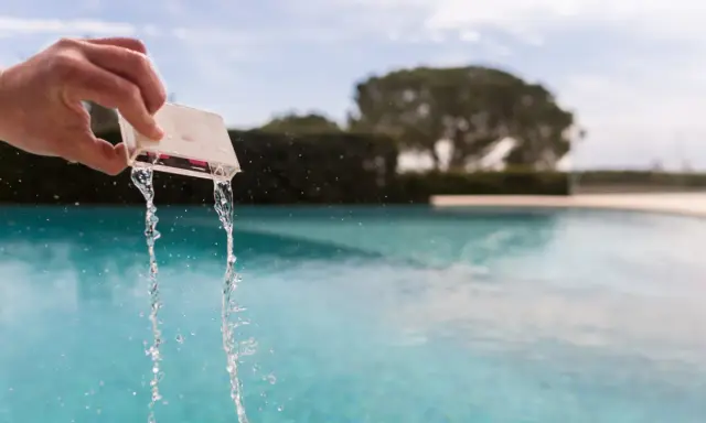 Mano che versa acqua da un contenitore per testare il cloro della piscina.