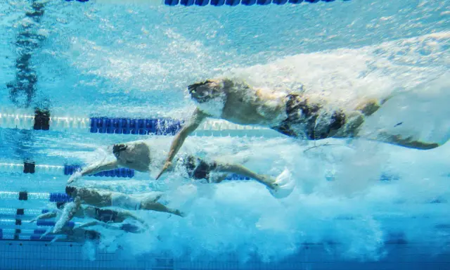 Nuotatori in azione, un allenamento nuoto principianti che mostra la determinazione e la tecnica sotto il pelo dell'acqua.