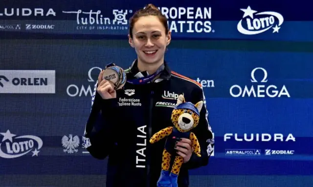 Anita Gastaldi sorride con una medaglia al collo e un peluche di ghepardo, celebrando una vittoria.