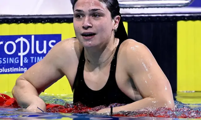 Benedetta Pilato, giovane campionessa di nuoto, emerge dall'acqua dopo una gara. La sua età non limita la sua forza.