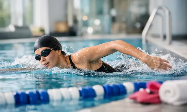 Donna nuota in piscina, bruciando calorie. Allenamento intenso per 30 vasche nuoto calorie.
