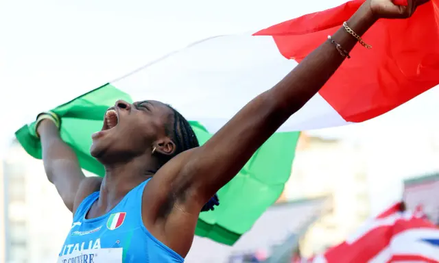 Atleta italiana esulta con la bandiera, un urlo di gioia per il record italiano 100 metri femminile.