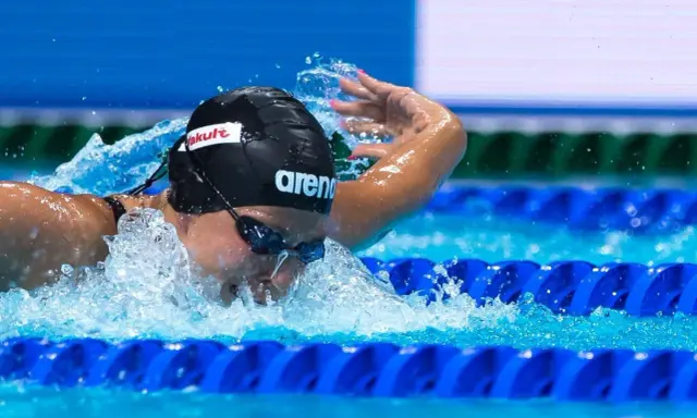 Stefania Pirozzi in azione, nuotando con determinazione. L'acqua schizza mentre si immerge per la prossima bracciata.