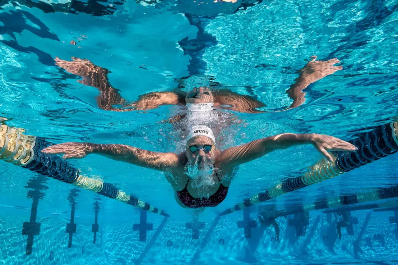 Nuotatrice Ruta Meilutyte in azione, vista da sotto la superficie dell'acqua. Le sue braccia si allargano mentre avanza nella corsia.