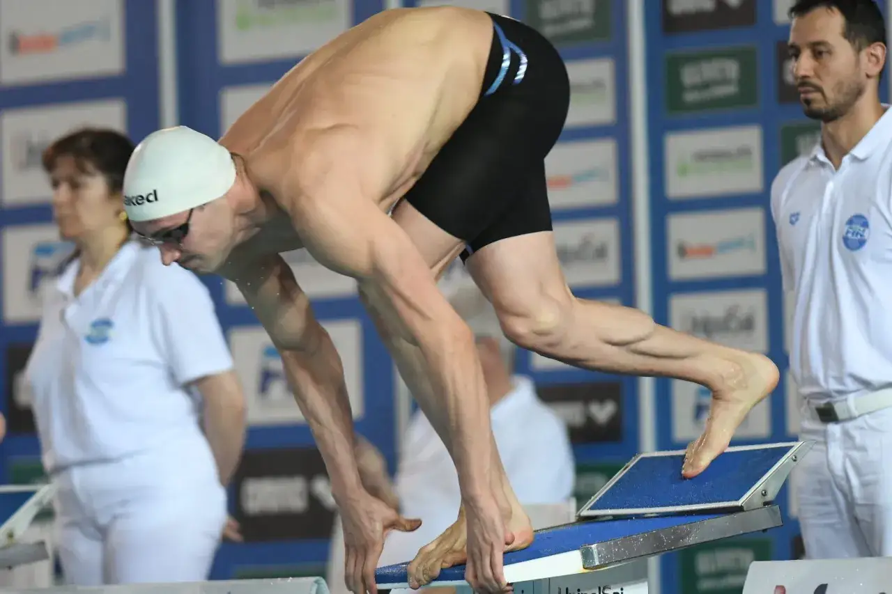 Fabio Scozzoli in posizione di partenza, pronto a tuffarsi in piscina.