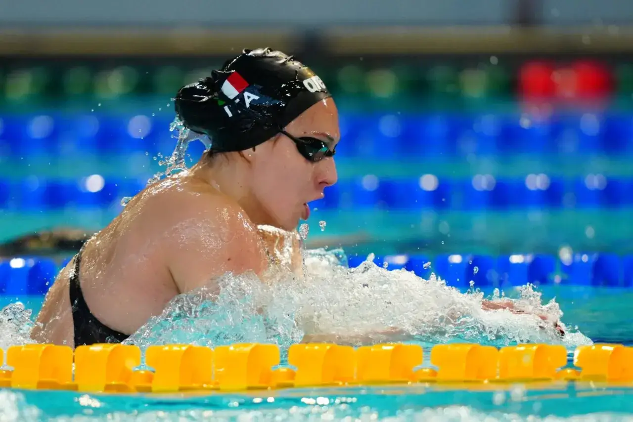 Anita Gastaldi in azione, nuotando a stile libero con determinazione. L'acqua schizza intorno a lei mentre gareggia in piscina.
