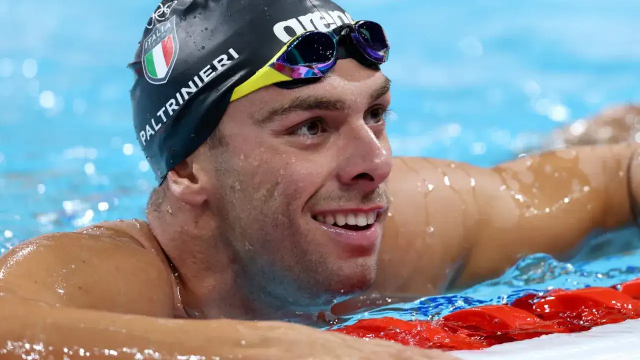 Nuotatore italiano Paltrinieri, sorridente in piscina, con la cuffia 