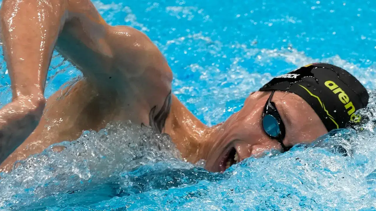 Atleta in azione durante le gare di nuoto, con la testa fuori dall'acqua e gli occhialini.