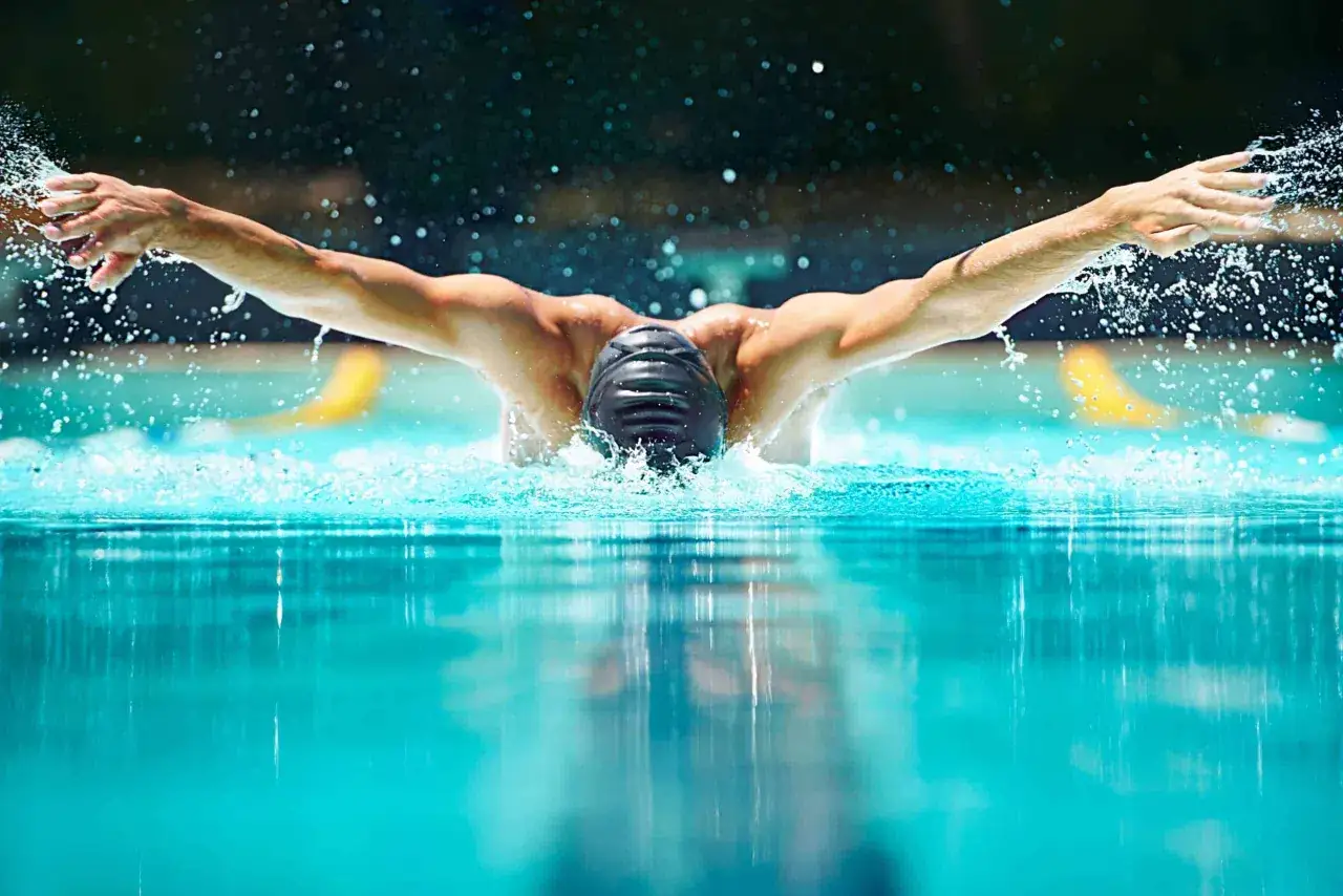 Atleta nuota a farfalla, un'immagine che evoca la disciplina e la dedizione necessarie per un esempio dieta nuoto agonistico.