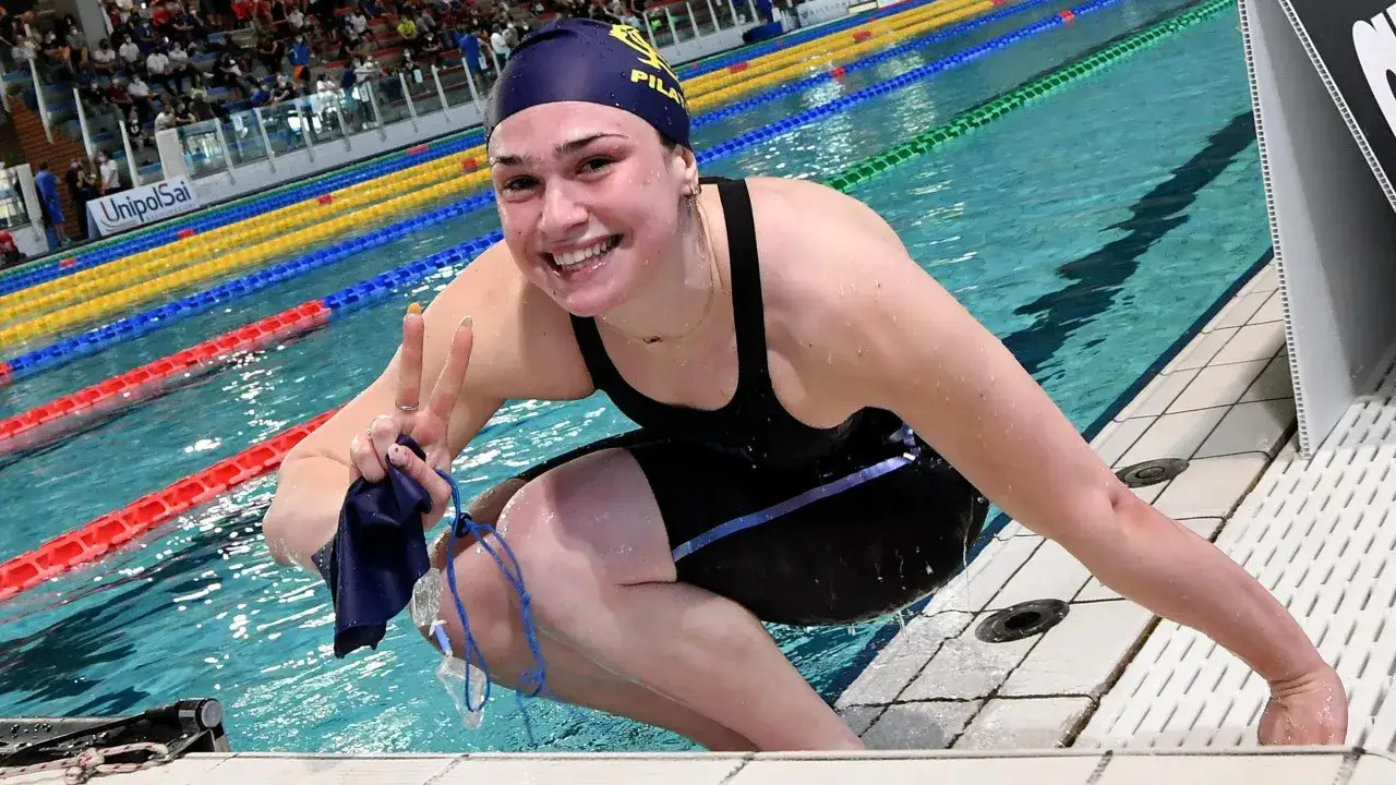 Benedetta Pilato, giovane nuotatrice, festeggia a bordo vasca. La sua et&agrave; non le impedisce di raggiungere grandi traguardi.
