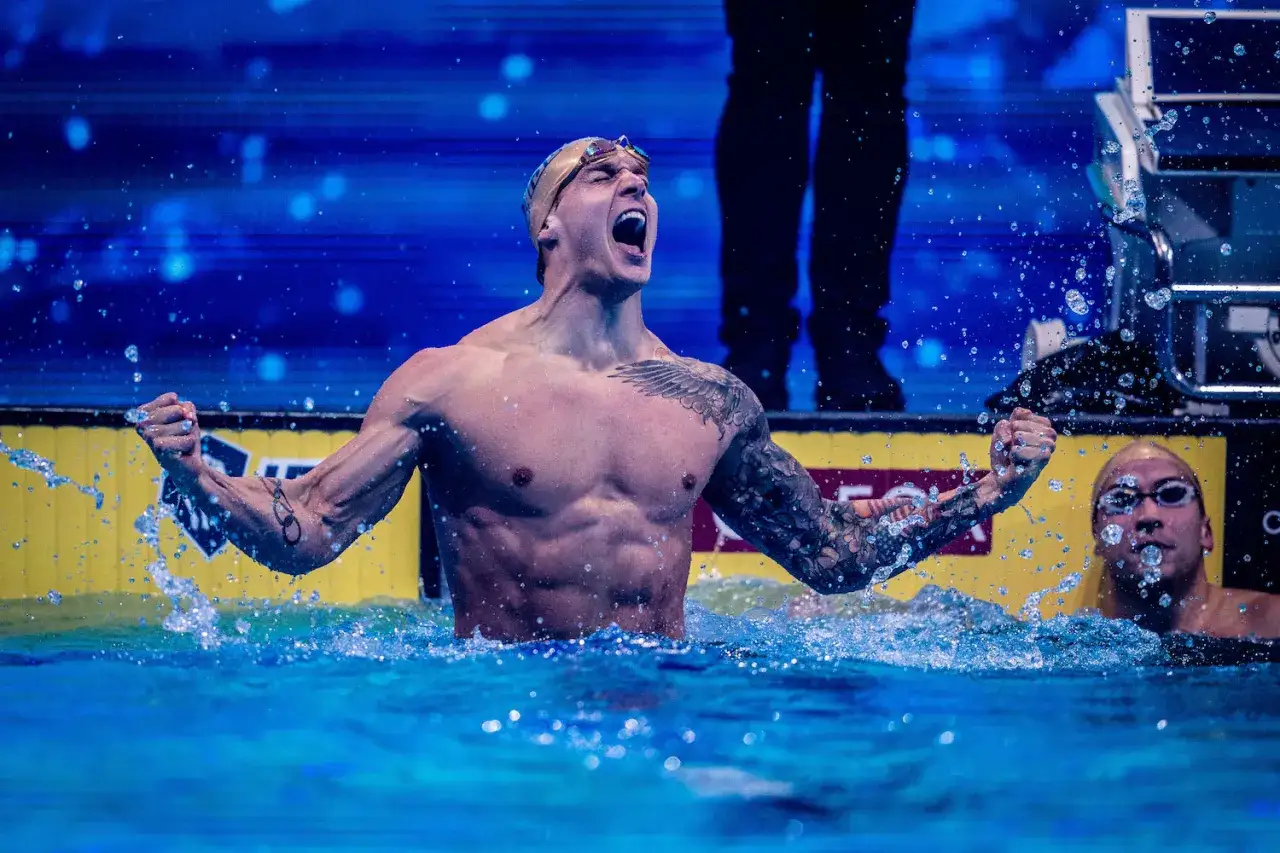 Il fisico di Nicolò Martinenghi esplode in un grido di gioia, circondato da spruzzi d'acqua.