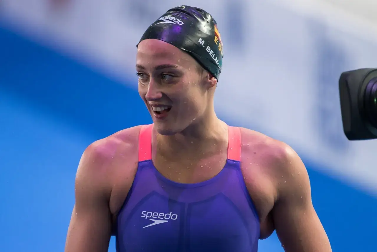 Mireia Belmonte, nuotatrice spagnola, sorride con gocce d'acqua sulla pelle, indossando una cuffia e un costume da gara.