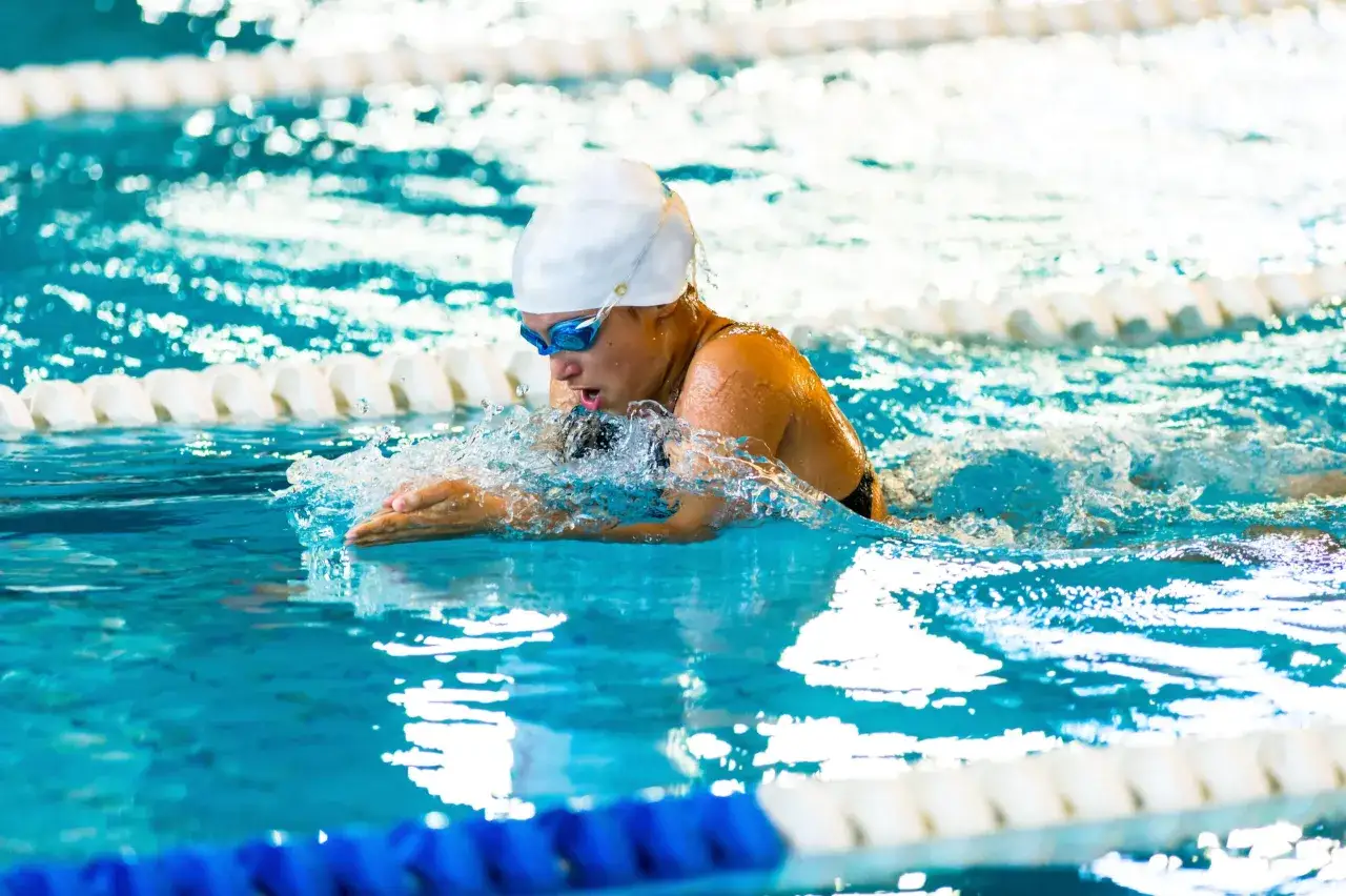 Nuotatore in piscina esegue la rana. Attenzione alle controindicazioni del nuoto a rana per chi ha problemi alle ginocchia.