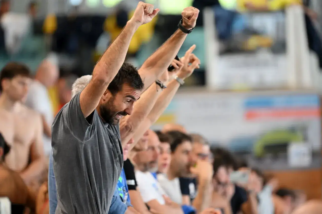 Fabrizio Antonelli esulta con il pugno alzato, circondato da spettatori in un evento sportivo.