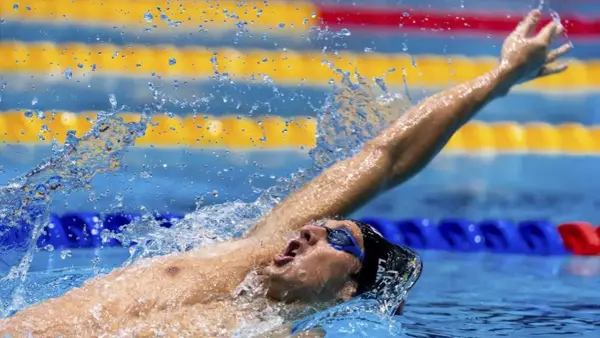 Michele Lamberti in azione, con il braccio teso e l'acqua che schizza, durante una gara di nuoto.