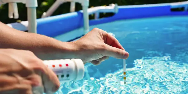 Controllo del cloro libero piscina con strisce reattive. L'acqua è cristallina, pronta per un tuffo rinfrescante.